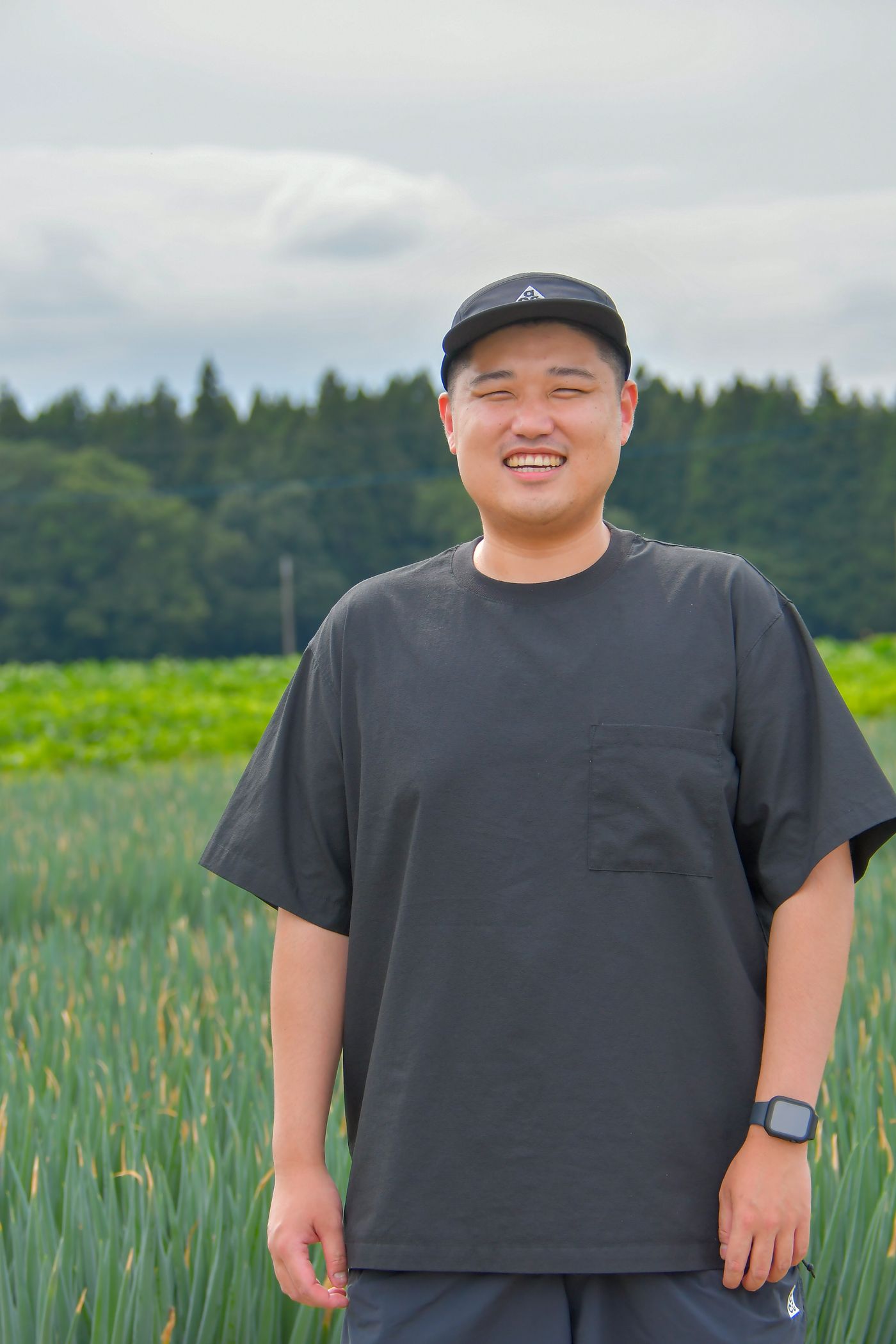 泉菜のねぎ畑に立つ、メディア事業部統括の奥山健太郎
